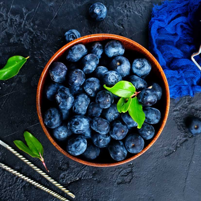 Top down Fresh blueberries in a wooden bowl